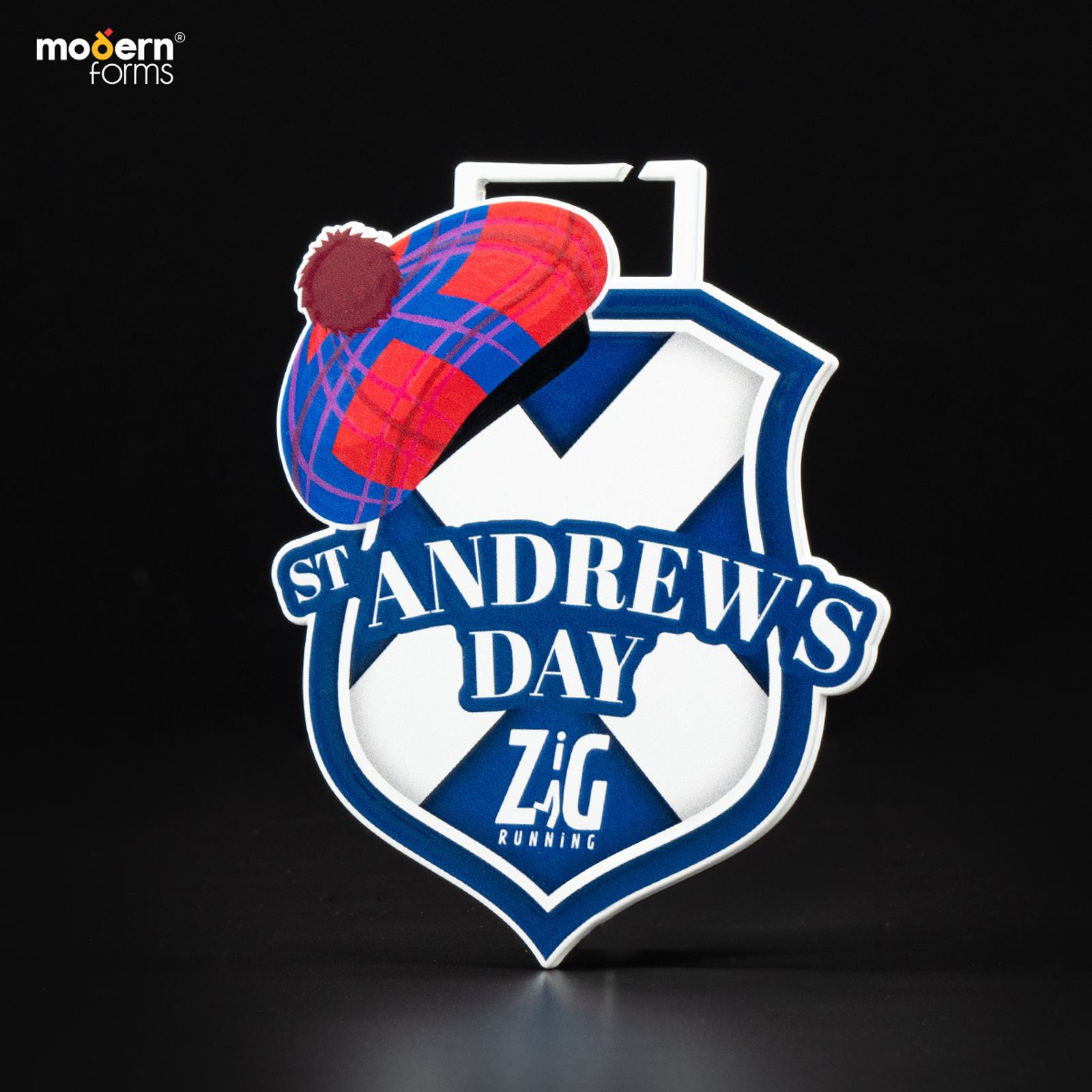 A badge design featuring "St. Andrew's Day" and "Zig Running," with a blue shield and a red tartan hat on top. The background is black, and "modern forms" is visible in the top left corner.