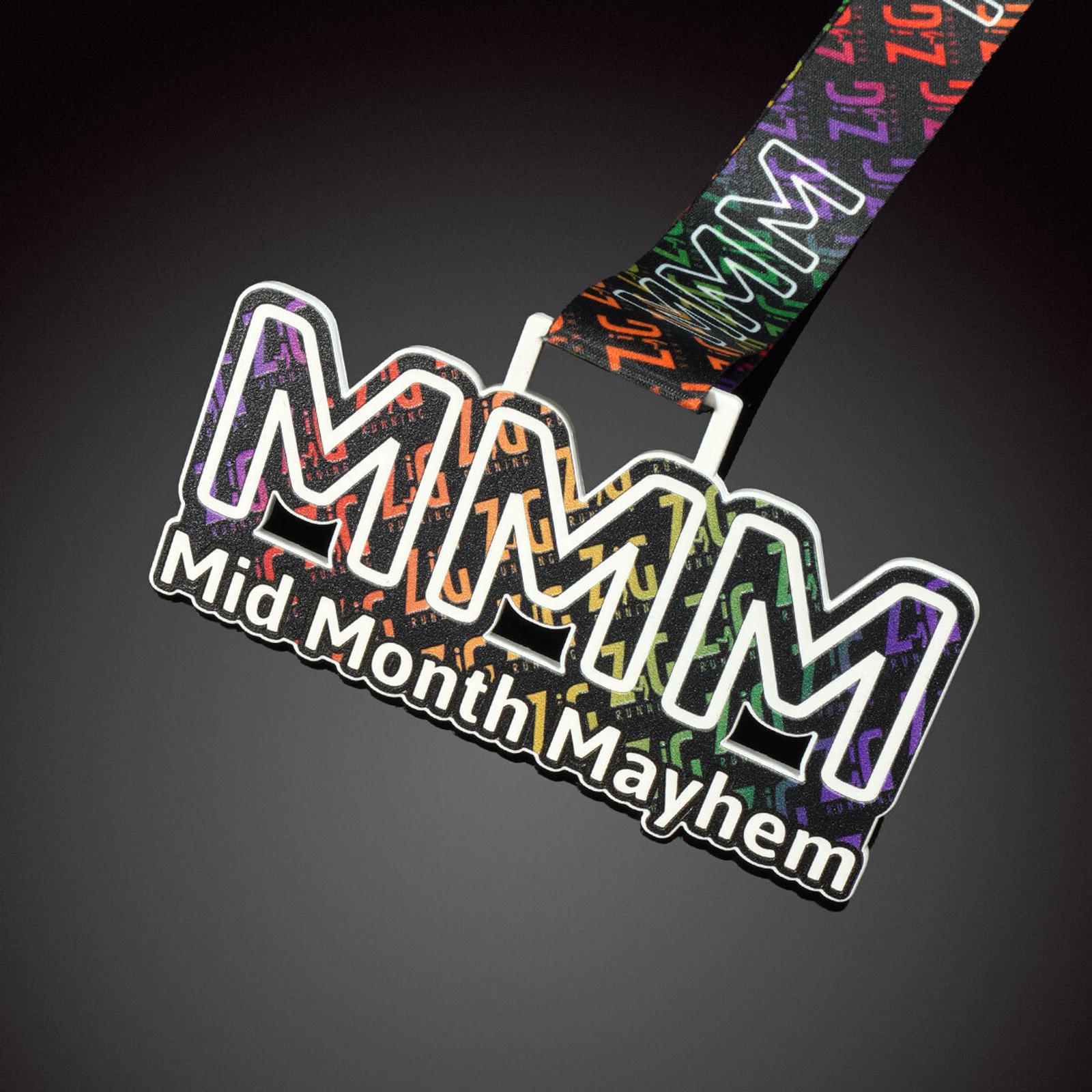 A colorful medal with the text "Mid Month Mayhem" written on it. The medal features a vibrant design with the letters "MMM" in large, bold font, and the lanyard is decorated with a pattern including the text "MMM" and colorful zigzag lines.