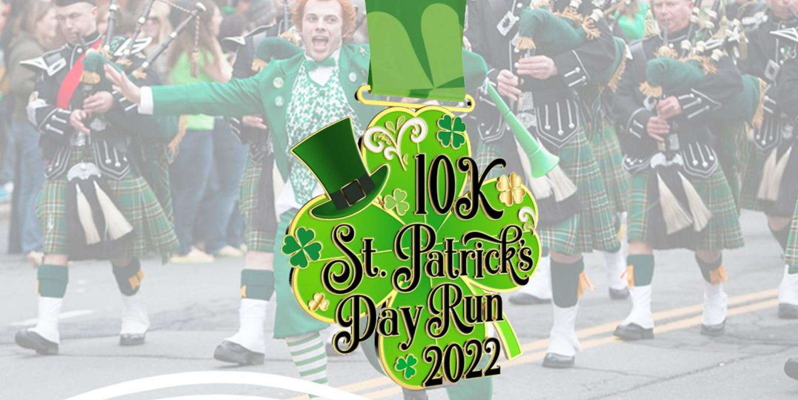 A group of people dressed in traditional Irish attire parade with bagpipes. A graphic in the front prominently reads "10K St. Patrick's Day Run 2022" in festive green letters with shamrocks and a leprechaun hat decoration.
