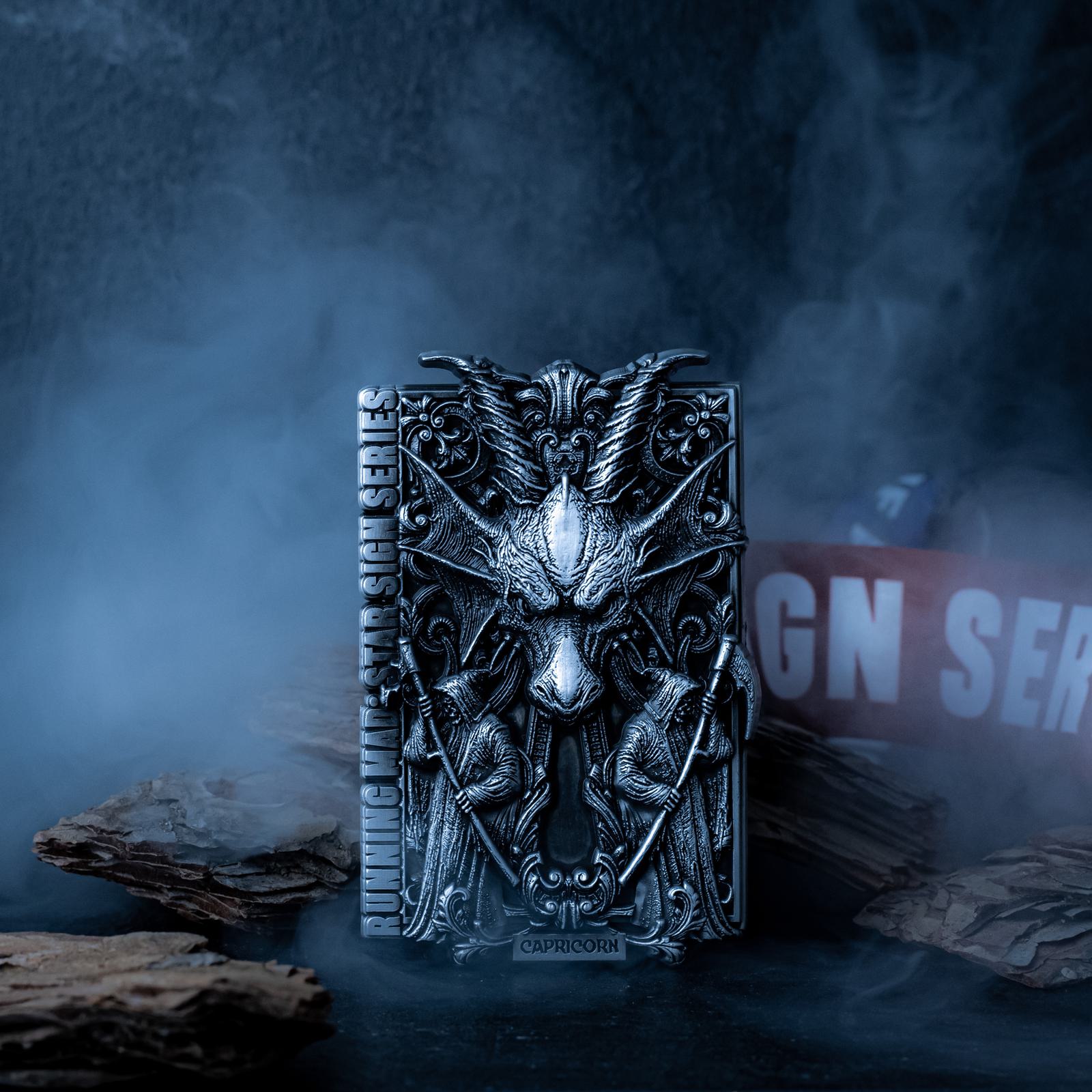 Ornate metallic object featuring a goat head emblem with intricate designs, labeled "Capricorn." The object stands amidst smoke and pieces of wood on a dark background.