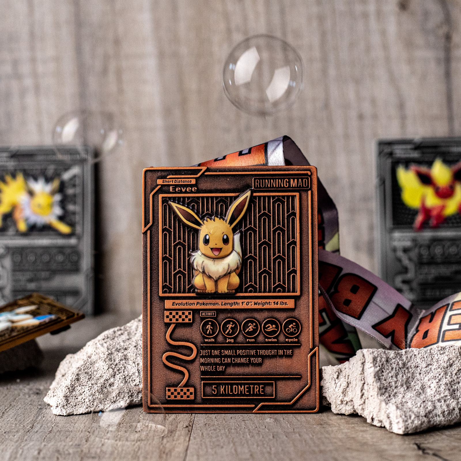 A Pokémon card featuring Eevee is displayed upright. The card has a detailed bronze design with various stats. Blurred cards and a comic-style book are in the background. Soap bubbles add a whimsical touch to the scene.
