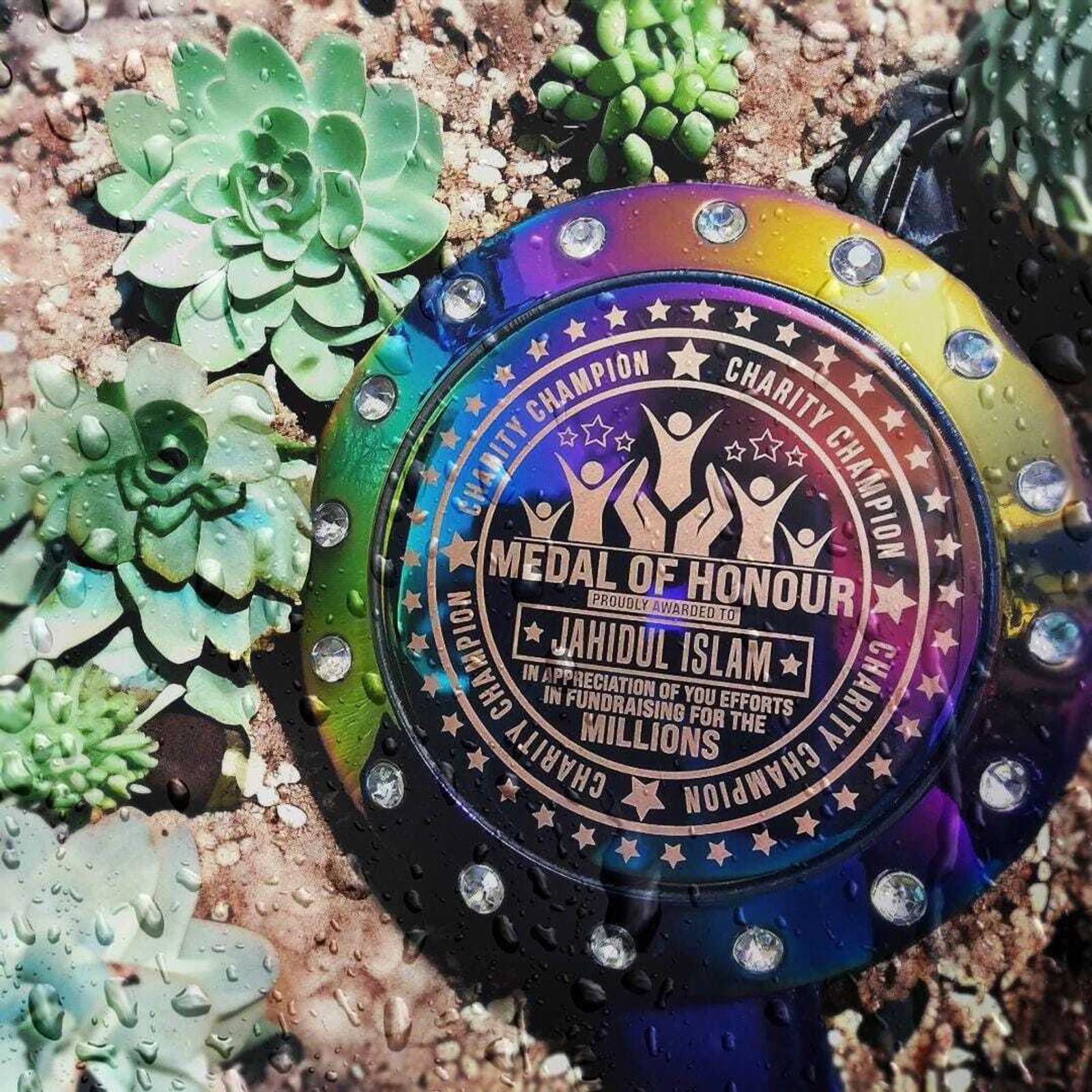 A colorful medal labeled "Medal of Honour" with "Charity Champion" and "Jahidul Islam." It's surrounded by succulent plants and water droplets.