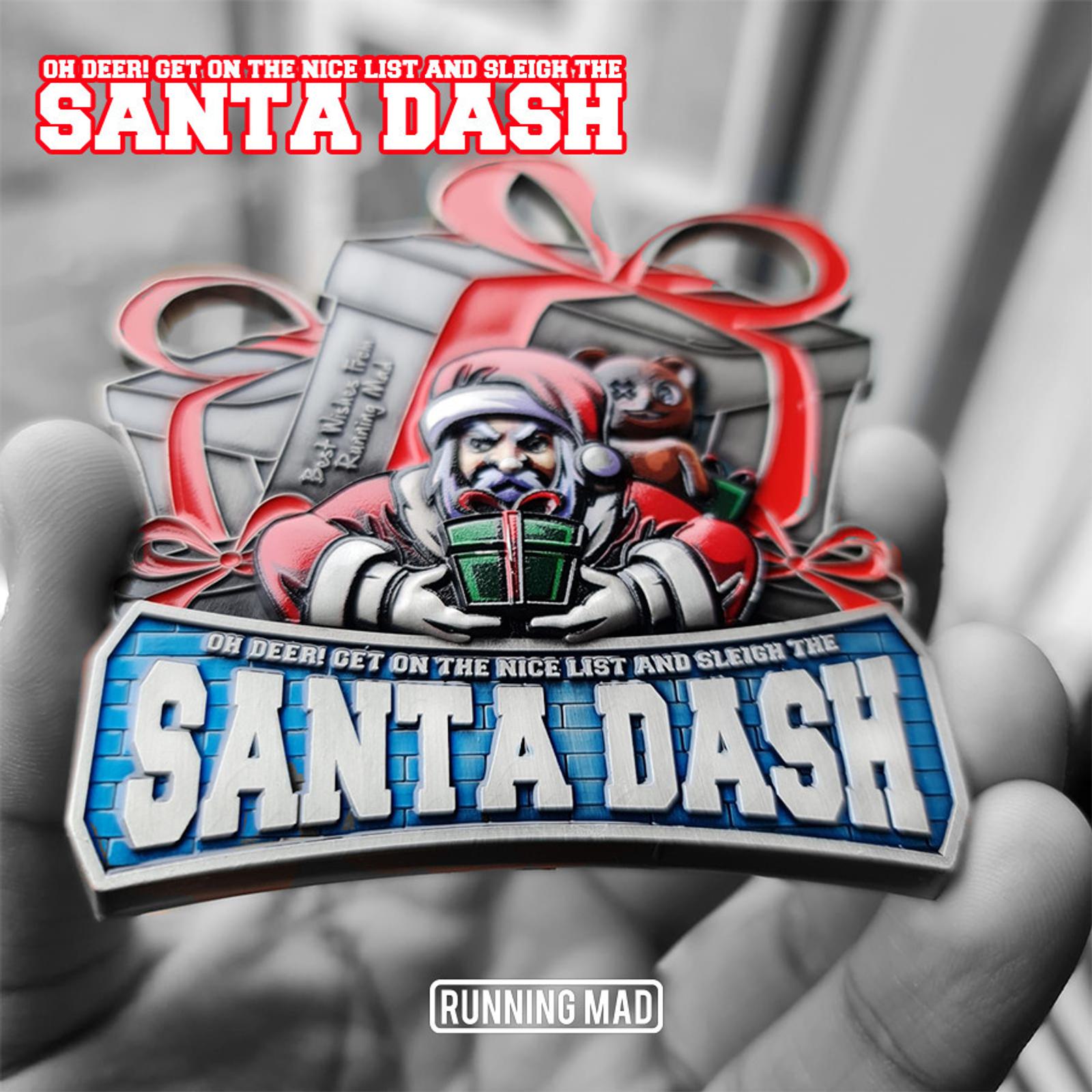 A person holding a Santa Dash medal featuring Santa Claus, a reindeer, and presents. The top text reads, "Oh Deer! Get on the Nice List and Sleigh the Santa Dash," with "Running Mad" at the bottom.