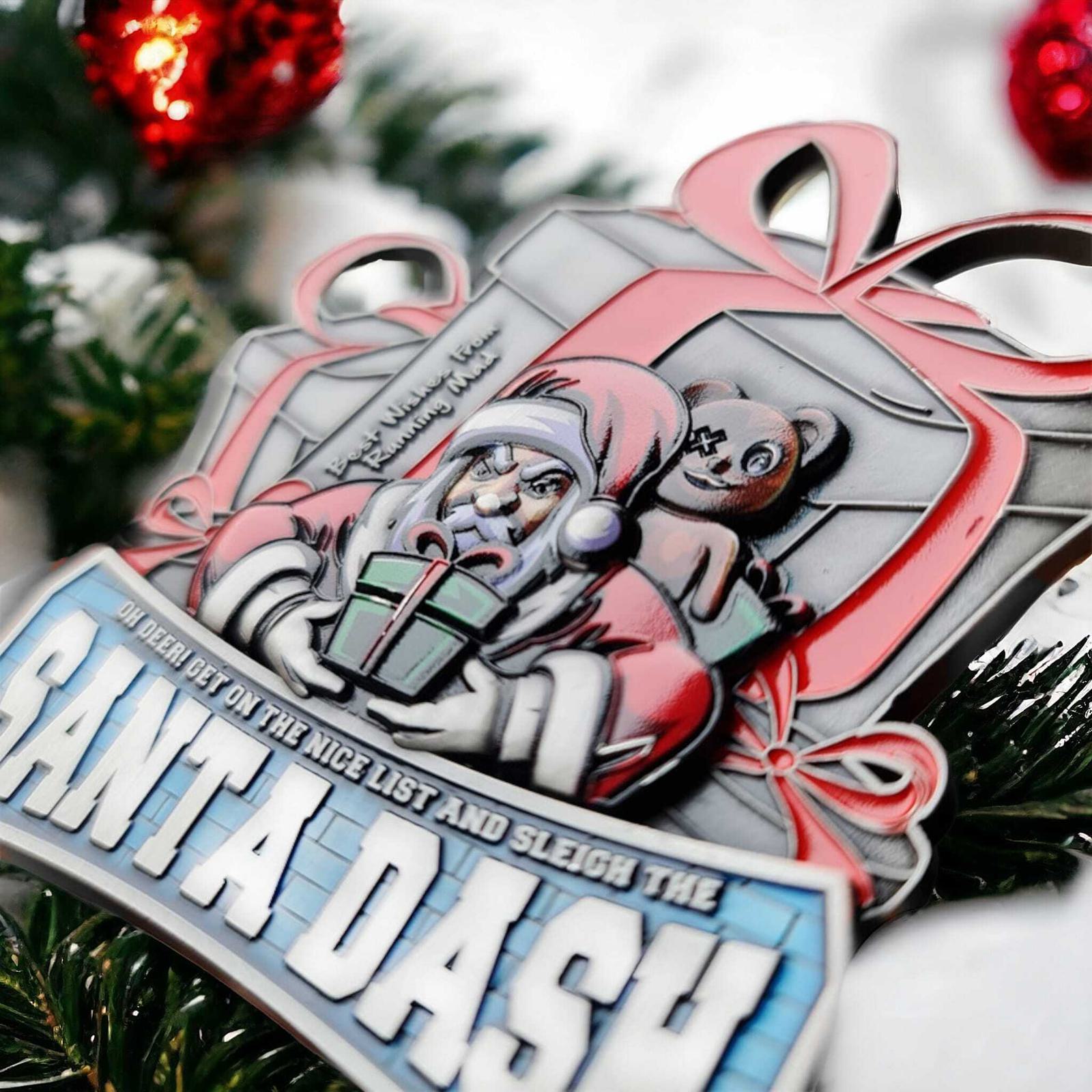 A festive medal featuring Santa Claus holding a gift with a teddy bear in the background. Above Santa is a large ribbon-wrapped gift box. The text reads "Santa Dash" and there's a festive arrangement with red baubles and greenery.