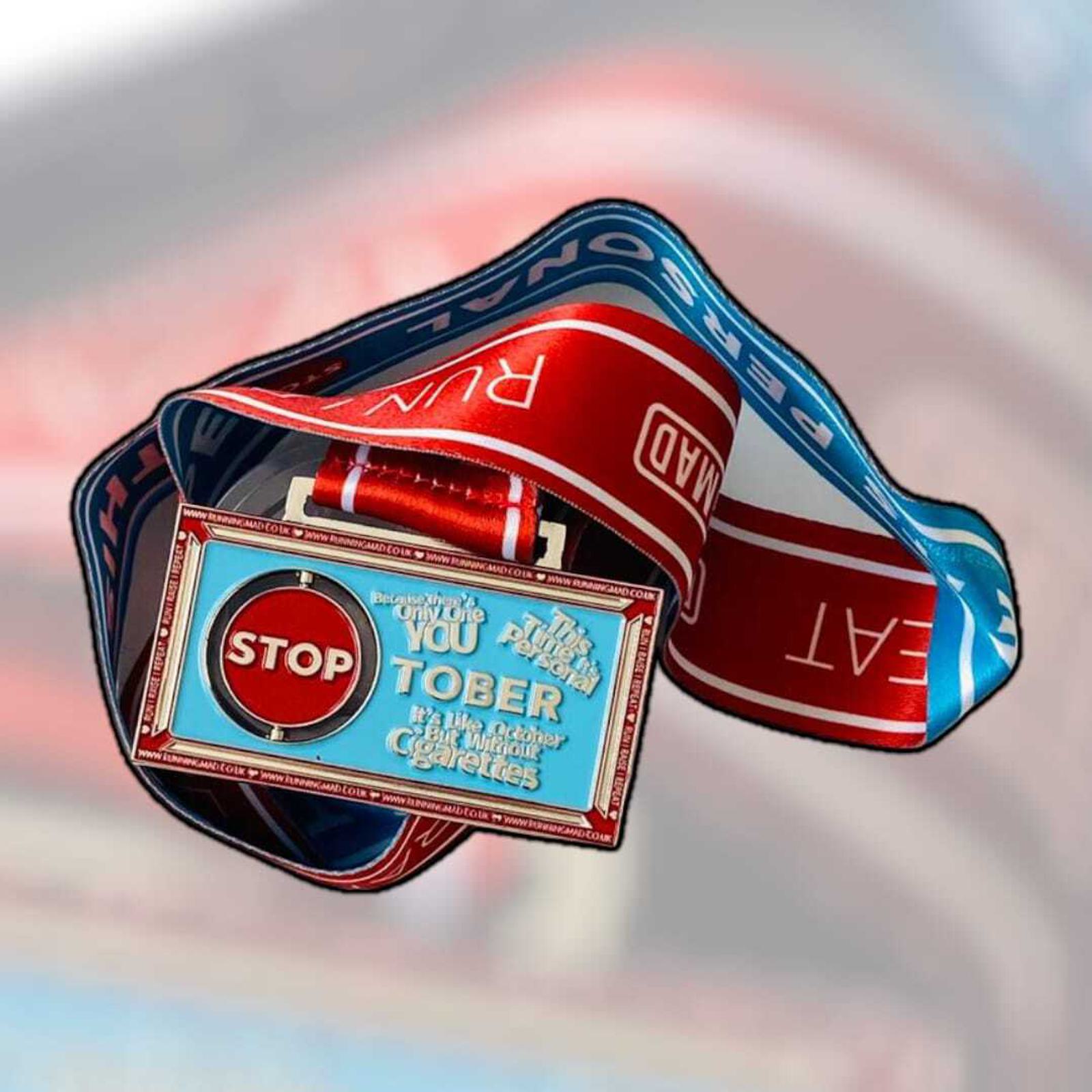 A colorful medal with a ribbon featuring words like "STOP" and slogans against tobacco and alcohol. The text on the medal reads motivational messages encouraging quitting smoking and drinking.