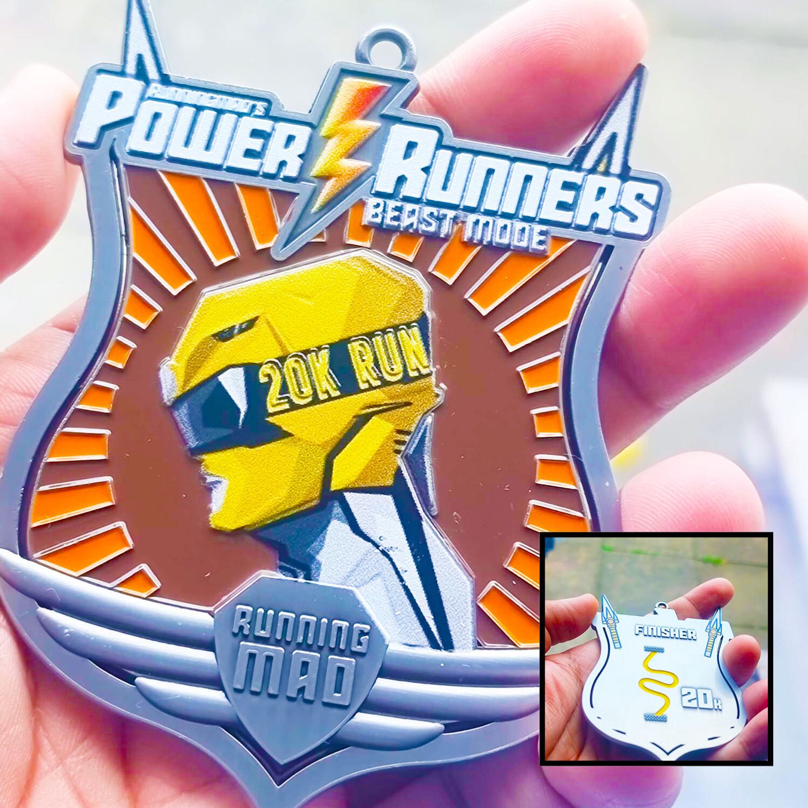 A medal designed for "Power Runners Beast Mode" featuring a helmeted figure and the text "20K Run Running Mad." A smaller inset shows a reverse view of the medal with "Finisher 20K." Both medals are held in a person's hand.