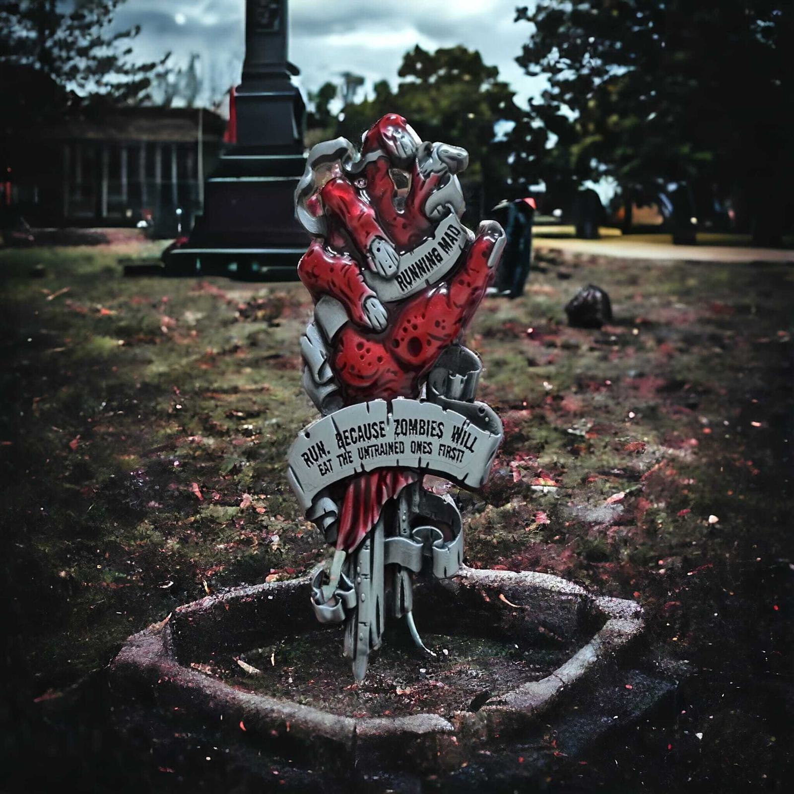 A graveyard scene featuring a colorful, cartoonish tombstone with two red zombies. The inscription reads, "R.I.P. because zombies will eat the untrained ones first." Trees and a monument are visible in the background under a cloudy sky.
