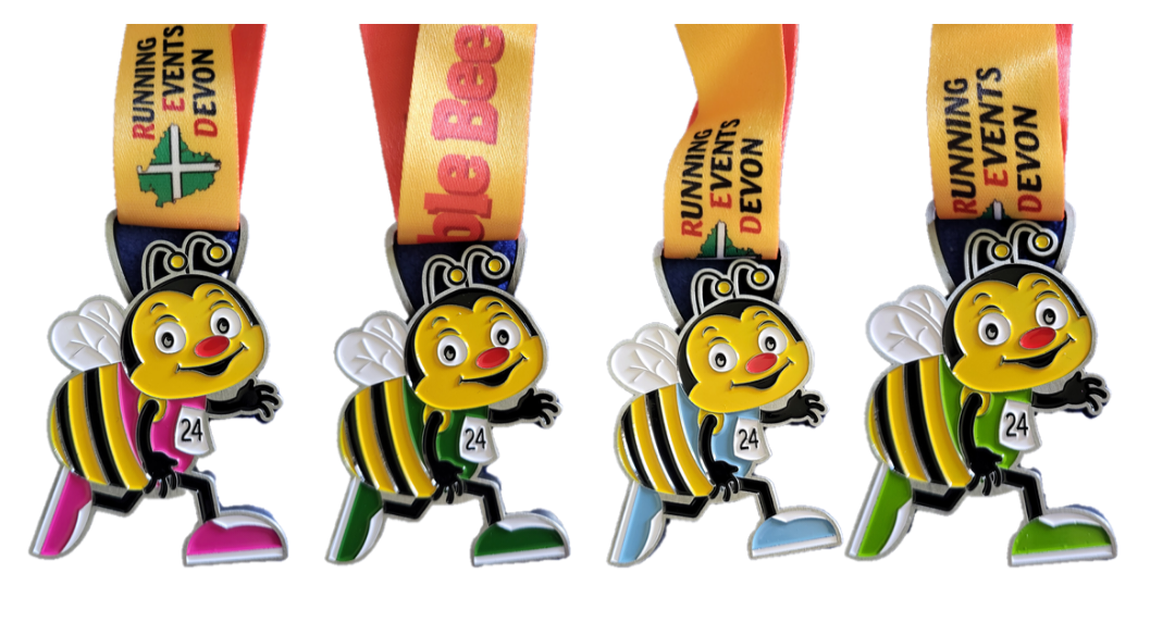 Four medals featuring a cartoon bee with white wings and striped yellow and black bodies. Each medal has different colored feet: pink, yellow, green, and blue. The ribbons read "Running Events Devon.