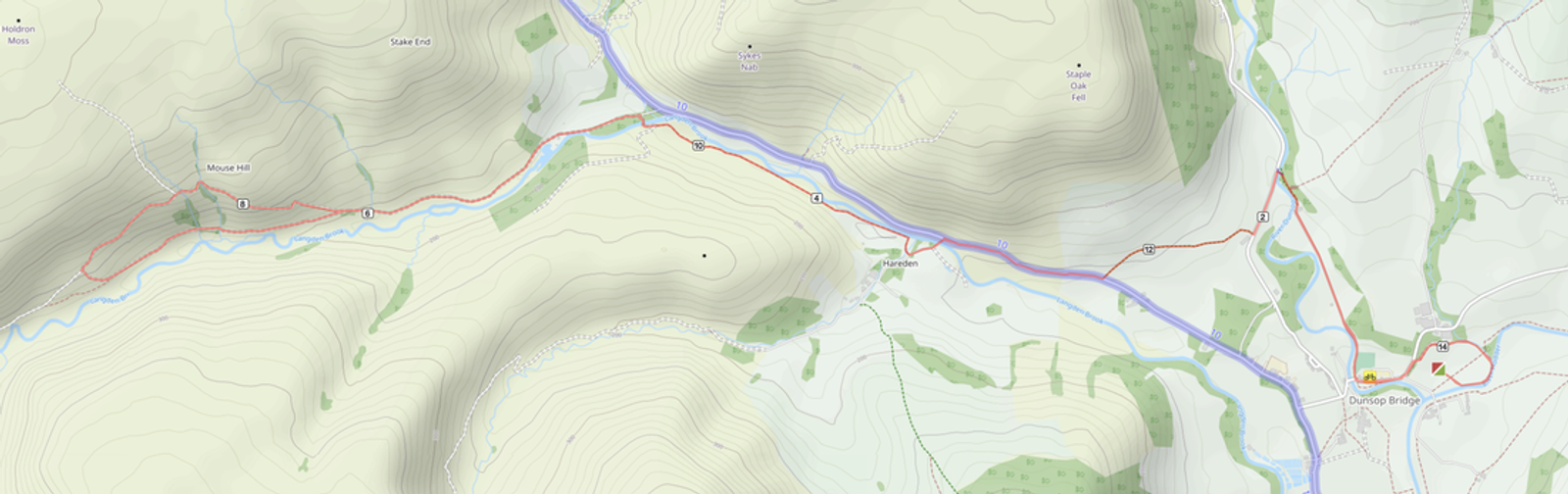 Topographic map showing a winding route through a hilly terrain with roads, rivers, and forested areas. The path leads from the left to the right across varying elevation, intersecting with a river and a road marked with bridges.