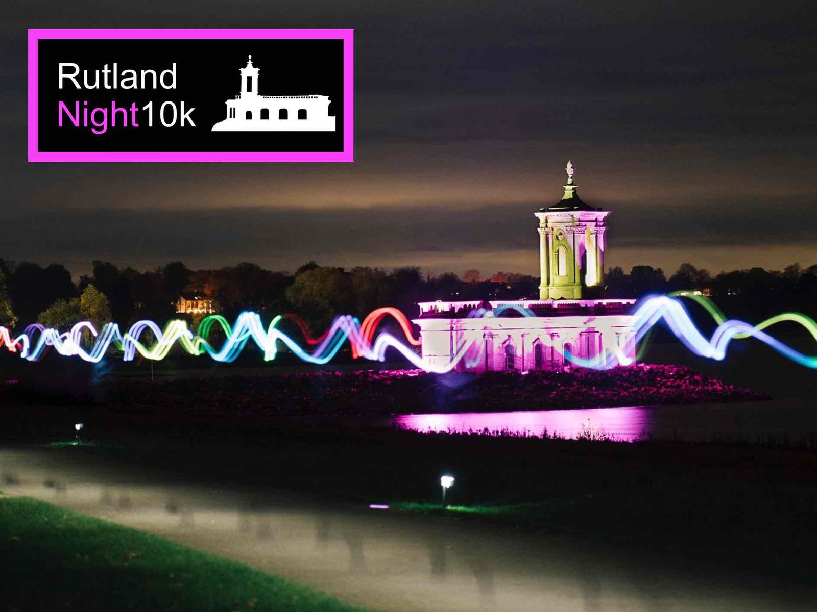 A night scene of Rutland Water with a lit-up church and colorful light trails; a logo in the top left reads "Rutland Night10k" with a silhouette of the church, all on a dark sky background.