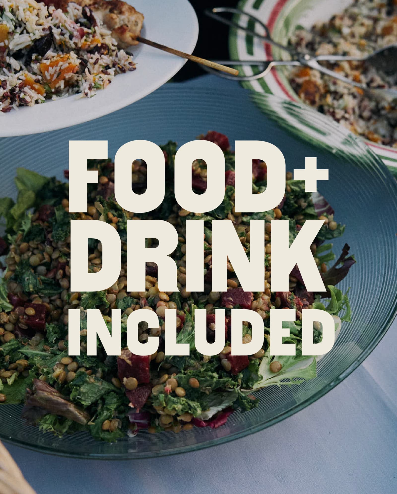 A glass bowl of salad and plates of food on a table, with the words “FOOD + DRINK INCLUDED” in bold white text across the center of the image.