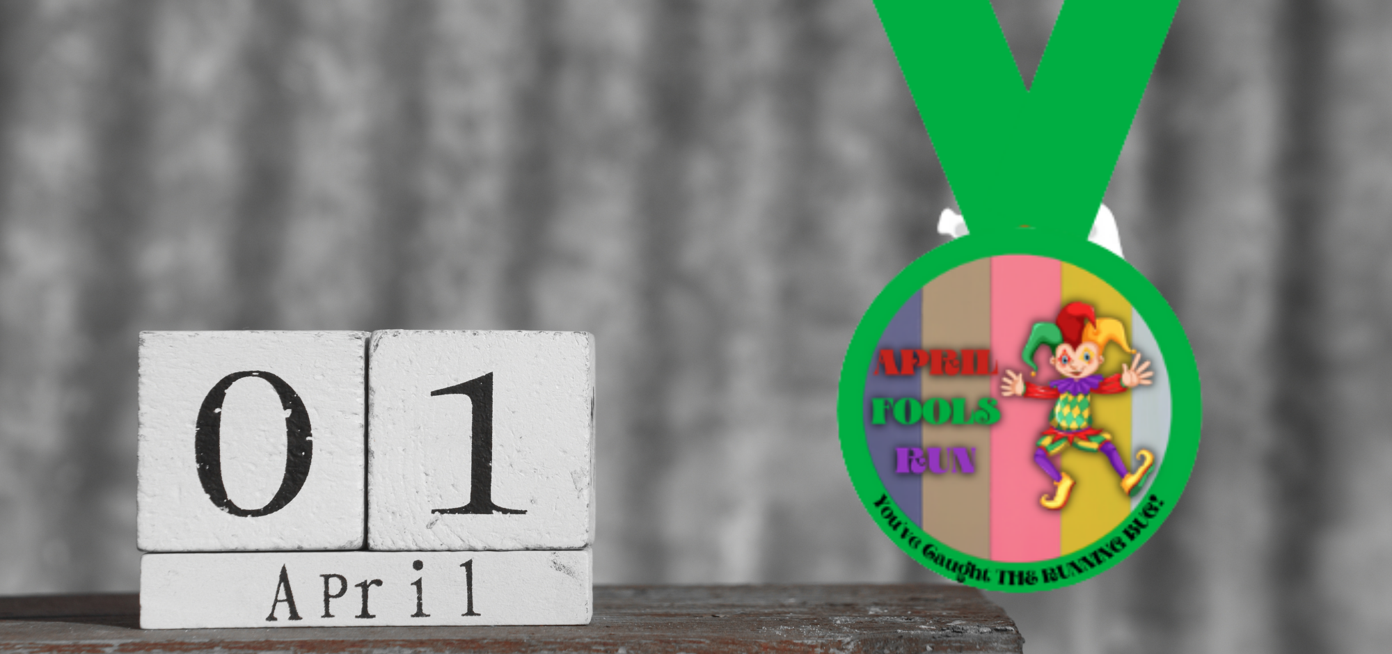 A desk calendar displaying "01 April" on wooden blocks is in the foreground. A colorful medal hangs nearby, with a jester and the words "APRIL FOOLS RUN" on the front, and text saying "5K/10K RUN-SPRINT WALK" along the bottom edge of the medal.