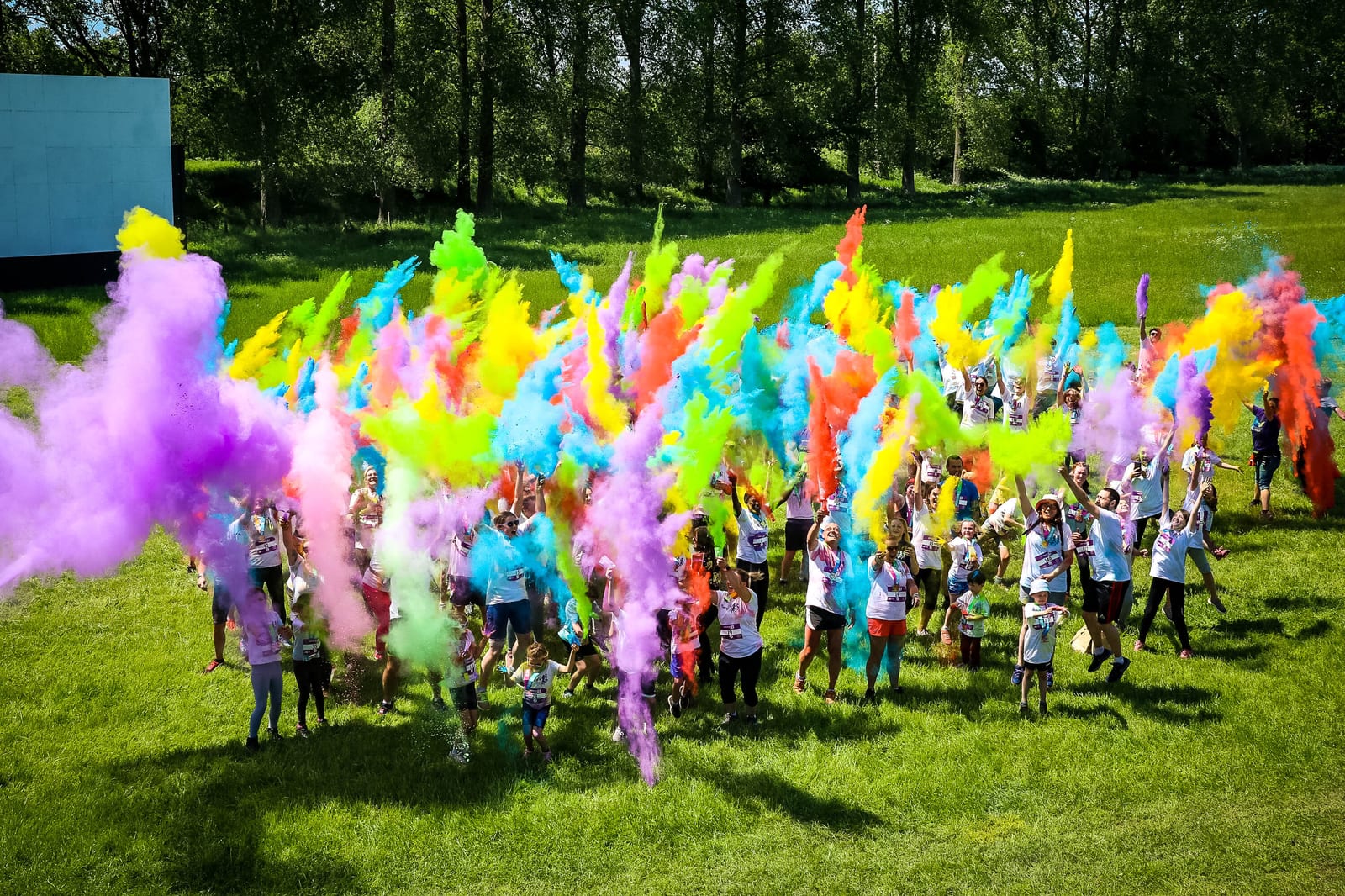 A group of people holding colorful smoke bombs.